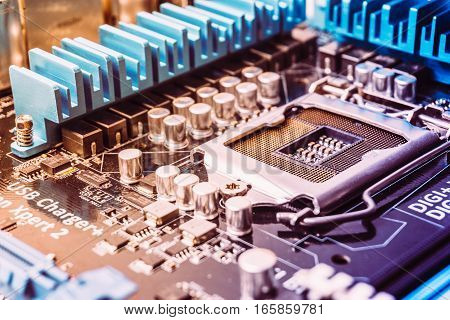 Printed circuit board with microchips and other electronic components. Socket for pc processor on mother board. Toned image.