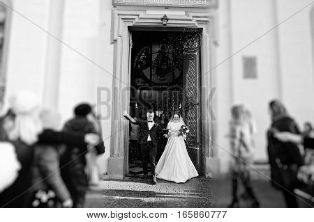 Guests Showered Newlyweds With Colorful  Rice After Wedding Ceremony At Church. Black And White Phot