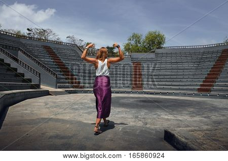 strong young woman enters a stadium with the will to win