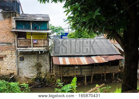 slums near dirty river with rooftop made from zinc photo taken in Depok Indonesia java