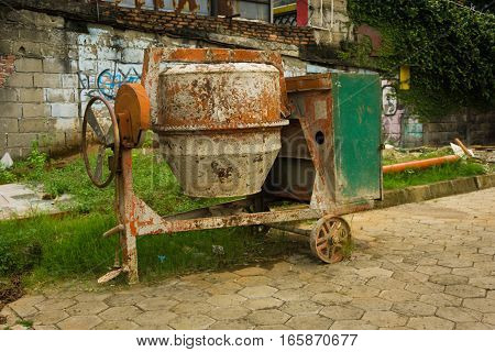 A dirty cement mixer abandoned in front of a house photo taken in Jakarta Indonesia java