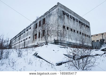 Exterior of housing of old decayed abandoned prison in Kolyma