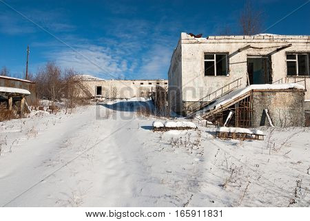 Abandoned prison settlement with decayed buildings in Northern Kolyma winter view