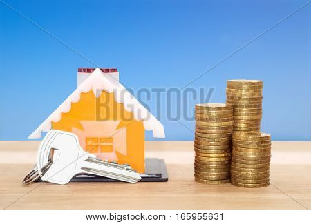 Sale and rental properties loans for real estate concept. Model home with key and coins