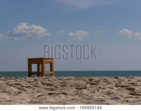 Sandy beach wooden stool in frint of the ocean
