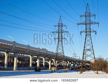 Industrial urban landscape with a transmission tower and the Western High Speed Diameter overpass. Saint-Petersburg Russia