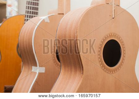 a row of classical unfinished guitar at workshop.