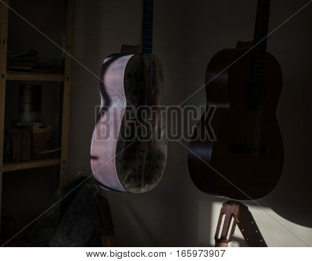 a row of classical unfinished guitar at workshop in sunlight.