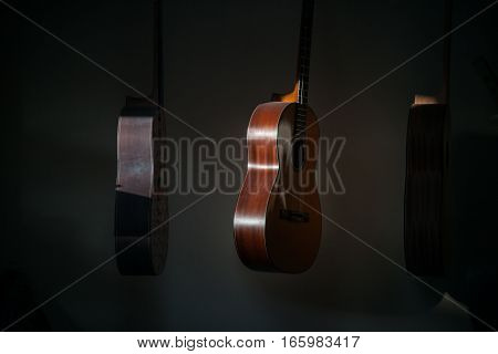 a row of classical unfinished guitar at workshop in sunlight.