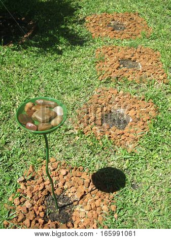 Road and water fountain for birds in the garden