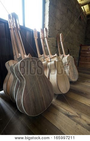 July 22, 2016 San Bartolome, Ecuador: unfinished classical guitars leaning against the wall in a small rural luthier shop
