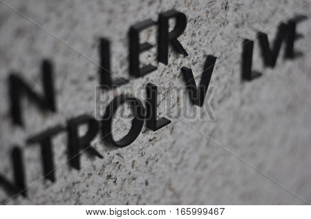 Missing letters in a signage on a stone wall