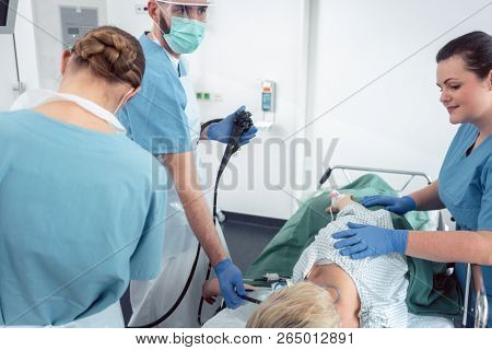 Team of doctors in hospital at endoscopy examining pictures during gastroscopy 