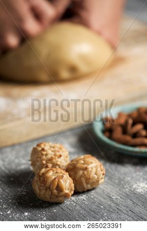 closeup of a young caucasian man preparing some panellets, sweet food typically eaten in All Saints Day in Catalonia, Spain