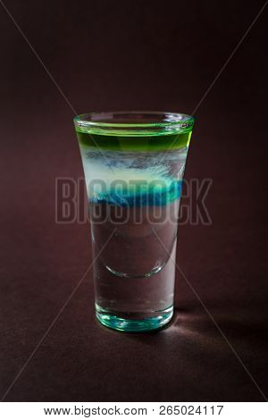 Clouds Alcoholic Shot Glass With Absent, Sambuca, Tequila, Blue Curacao On Elegant Dark Brown Backgr