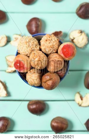 high angle view of some chestnuts and some panellets, as a typical snack eaten in All Saints Day in Catalonia, Spain, called castanada
