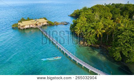 Aerial resort and wild tropical forest and coastline view over Hatta island, Maluku, Indonesia