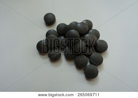 Closeup Of Heap Of Black Round Pills Of Chelated Iron