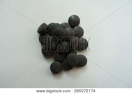 Heap Of Round Black Pills Of Chelated Iron From Above