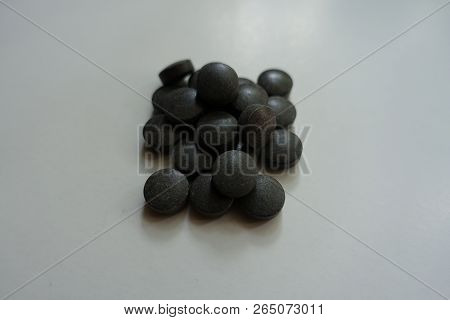 Round Black Pills Of Chelated Iron In A Heap