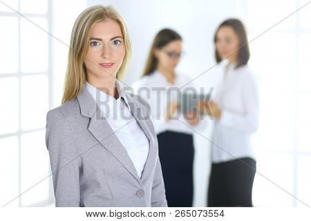 Attractive Business Woman Working With A Tablet Pc Against The Background Of Colleagues. Lawyer Or S