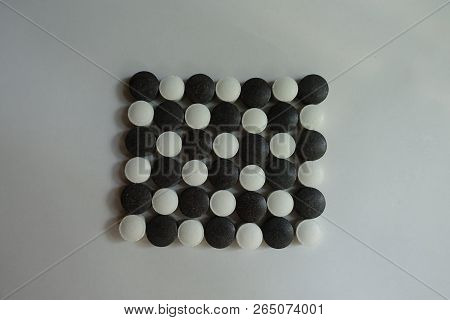 Check Pattern Made Of Black And White Round Pills