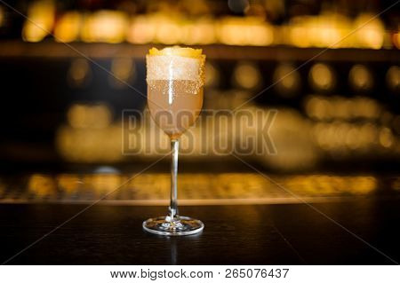 Elegant Sweet Wine Glass Filled With Tasty Brandy Crusta Cocktail On The Bar Counter Against Dark Ba