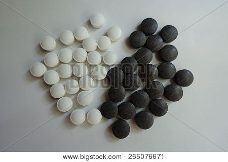 View Of Group Of Black Chelated Iron And White Vitamin K Pills From Above