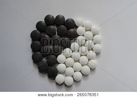 Black And White Pills In Shape Of Yin And Yang Symbol From Above