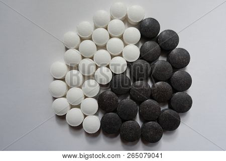 View Of Yin And Yang Symbol Formed Of Black And White Round Pills From Above