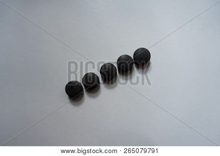 Line Of Five Round Black Tablets Of Chelated Iron