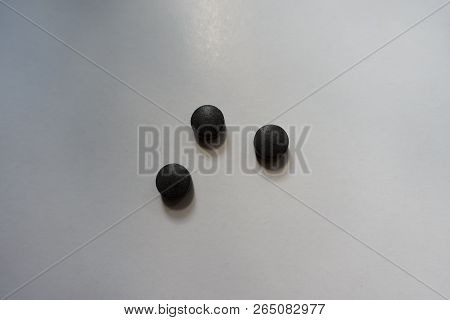 Three Round Black Pills Of Chelated Iron From Above