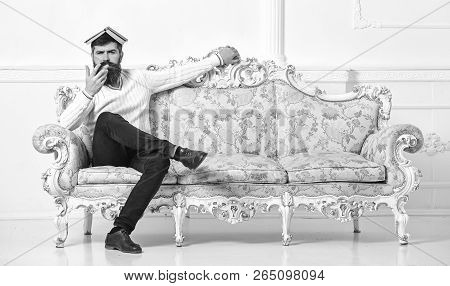 Macho Sits With Open Book On Head, Like Roof. Overstudy Concept. Man With Beard And Mustache Sits On