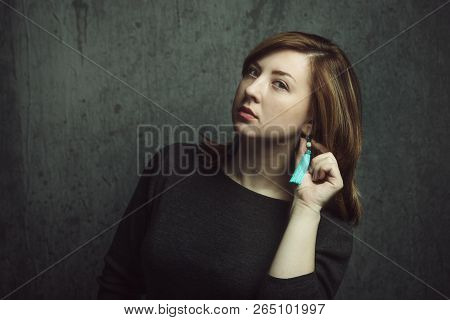 Vintage Portrait Of Beautiful Stylish Girl With Turquoise Earrings On Gray Studio Background.