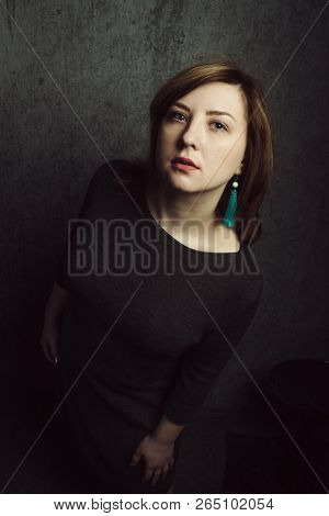 Vintage Portrait Of Beautiful Stylish Girl With Turquoise Earrings On Gray Studio Background.