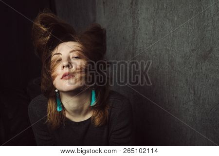 Vintage Portrait Of Beautiful Stylish Girl With Turquoise Earrings And Flying Hair On Gray Studio Ba