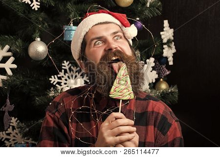 New Year Guy Lick Candy Or Sweet. Christmas Man With Beard On Happy Face And Lollipop. Winter Holida