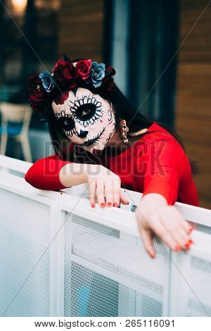 A Girl With A Painted Face Of A Skeleton, A Dead Zombie, In The City During The Day. Day Of All Soul