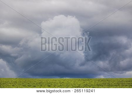Minimalism Photo Of A Dramatic Cloud Over A Green Field.