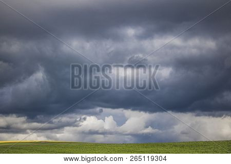 Minimalism Photo Of A Dramatic Clouds Over A Green Field.