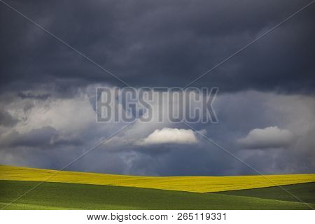 Minimalism Photo Of A Dramatic Clouds Over A Green And Yellow Fields.