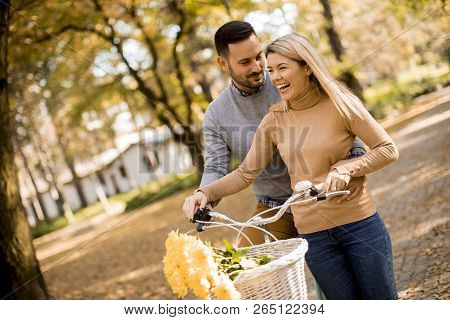 Active Senior Couple Together Enjoying Romantic Walk With Bicycle In Golden Autumn Park