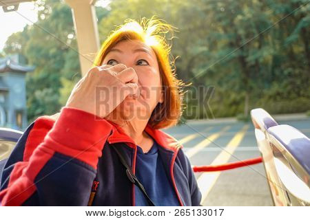 Portrait Photo Of Senior Asian Women Smell Her Hand And Look Up On The Tourist Bus In Foshan Xiqiao 