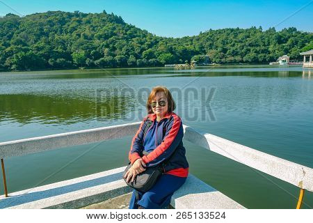 Senior Women Tourist Sitting On Stone Chair Beside The Lake On Top Of The Xiqiao Mountain Foshan Cit