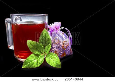 A Mug Of Tea On A Black Background, And Next Is A Green Mito