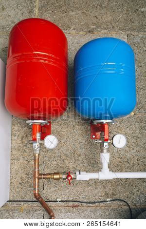 red and blue expansion tanks in boiler room