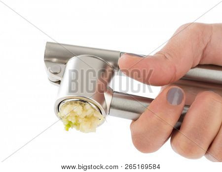 Femle hand pressing garlic masher isolated on white background.    