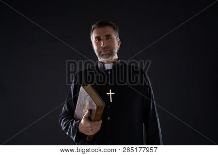 Priest portrait with Holy Bible in hands isolated