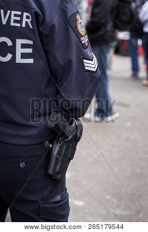 Vancouver, Bc, Canada - May 11, 2016: A Close-up Of A Vancouver Police Officers Gun And Crest As The