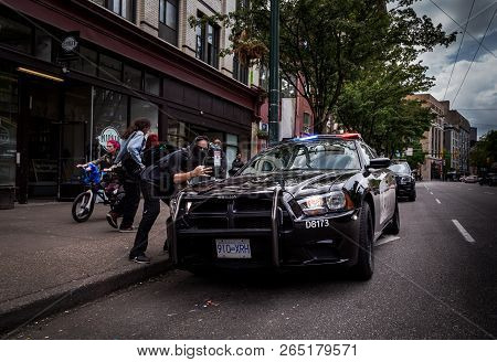 East Vancouver, Bc, Canada - May 11, 2016: Man With A Bandanna Covering His Face Shows The Hand-sign